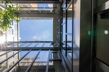 Vue intérieure d’un patio entièrement fermé par des façades vitrées, laissant apparaître le...