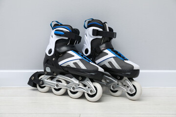 Pair of roller skates on floor near white wall