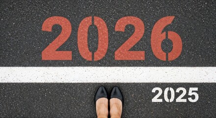 Paving way to 2026 new year concept with painted figures on asphalt road, depicting transition from 2025. Planning for 2026 new year ahead, shows commitment and vision.