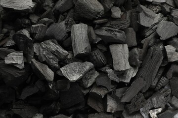 Pieces of black coals as background, top view