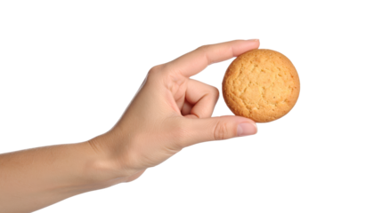 Closeup of a hand holding freshly baked cookie against black background