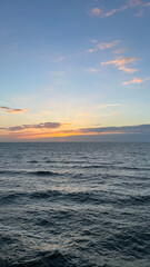 Peaceful Sunset Over Ocean Waves with Soft Clouds and Golden Light