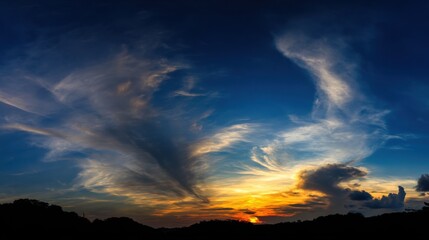 Obraz premium Expansive panoramic view of a dramatic sunrise or sunset with vibrant sky colors transitioning from deep blues to warm r