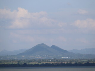 Majestic Mountain Vista: A serene panorama showcases a stunning mountain range under a cloudy sky,...
