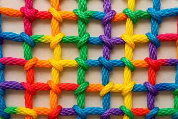 Close-Up of Rainbow Colored Rope Grid with Interwoven Knots and Rich Colorful Texture