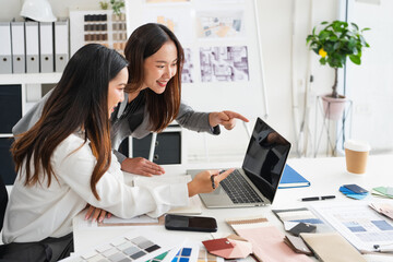 Two asian female interior designer or architect working on creative project with drawing, material sample , laptop computer in office. Business of Real estate, home decoration , renovation concept.