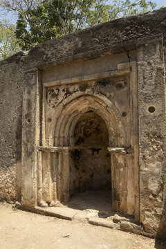 View of an ancient stone doorway with intricate carvings stands as a time capsule in the weathered ruins, whispering tales of the past, Gede, Kilifi County, Kenya.