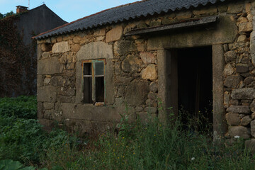 Weathered stone dwelling revealing structural deterioration, symbolizing rural abandonment and...