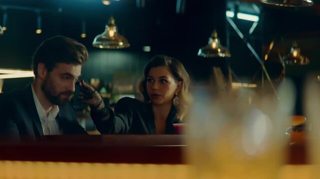Beautiful Caucasian couple having a date in a stylish restaurant, talking and laughing. Shot with 2x anamorphic lens