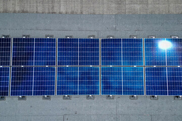 Vue aérienne de panneaux photovoltaïques installés sur le toit d’un bâtiment industriel sous...