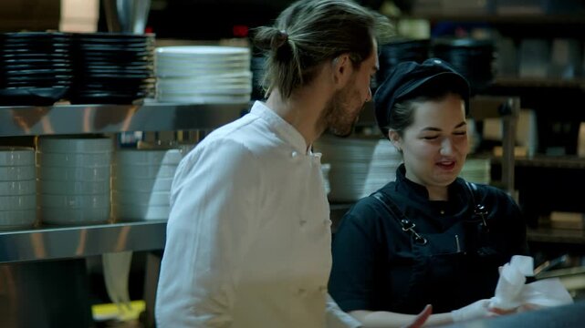 Portrait of Caucasian male chef working on busy commercial restaurant kitchen. Shot with 2x anamorphic lens