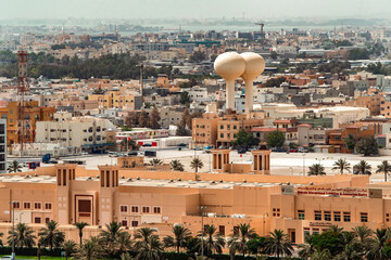 Aerial view of the beige-toned Bahrain International Exhibition & Convention Centre and dual water towers stand amidst the cityscape, Manama, Capital Governorate, Bahrain.