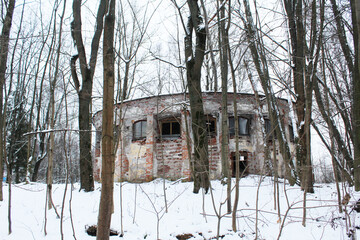An old abandoned building in winter among the trees. Abandoned building