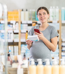 Interested pregnant woman scans a package of toxicosis pills on a mobile barcode and reads detailed...