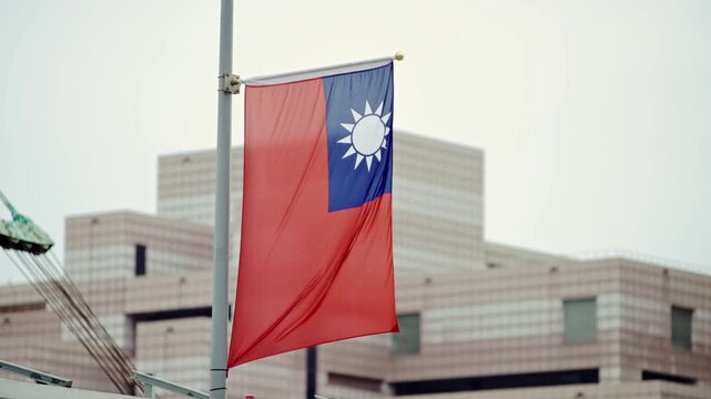 Slow motion of Taiwan flag displayed at the entrance of a modern building, highlighting national pride in an urban setting.