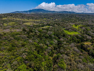 Fototapeta premium Beautiful aerial view of wind Mills - turbines- on Costa Rica’s hills of Guanacaste, vibrant skies, renewable energy, and a stunning mountain landscape
