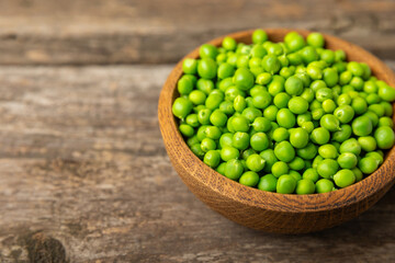 Fresh green pea pods with green peas on a wooden background. Sweet green peas. Green pea beans vegetables. Vegan. healthy vegetable. Copy space