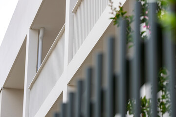 Vue sur des barrières de balcon classiques de couleur crème, intégrées à une façade sobre et...