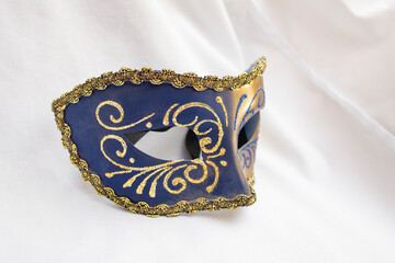 Blue colored carnival mask with golden glitter decorations, close up isolated on white