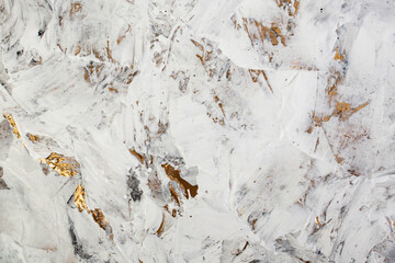 Putty white paste mixed with black ink, abstract close up detail of spatula strokes on golden paint...