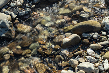 Rapid water stream river close up with sunlight  and motion blur