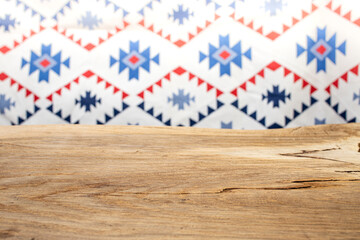 Empty wooden desk with east european motifs defocused wallpaper, copy space for product placement, abstract backdrop