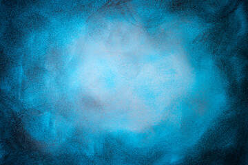 Charcoal and chalk smudges and smears on blue colored paper, abstract vignette backdrop, close up texture