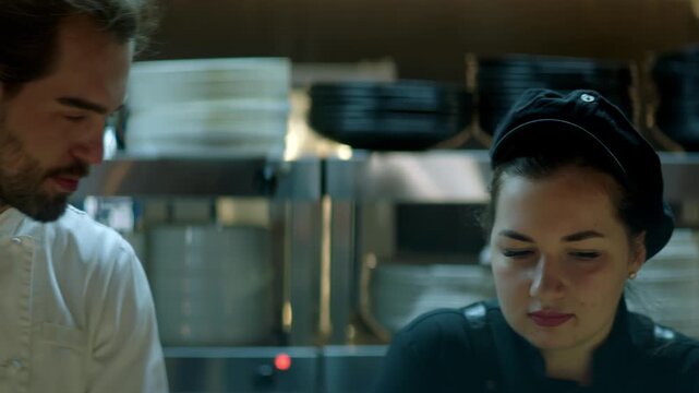 Portrait of Caucasian male chef working on busy commercial restaurant kitchen. Shot with 2x anamorphic lens