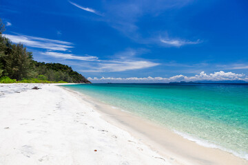 Koh Adang, Thailand. Crystal-clear turquoise Andaman sea meets pristine sandy beach under blue sky. Beautiful tropical landscape. White sand coast of Adang island.
