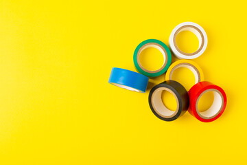 Insulating tape on a bright colored background. Set of different colors insulating tape. Reel...