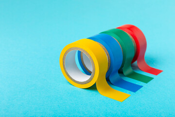 Insulating tape on a bright colored background. Set of different colors insulating tape. Reel...