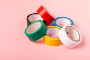 Insulating tape on a bright colored background. Set of different colors insulating tape. Reel...