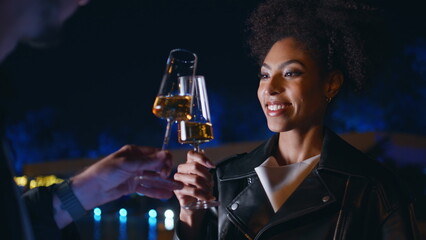 Smiling woman enjoying celebration at night street closeup. Happy lady toasting