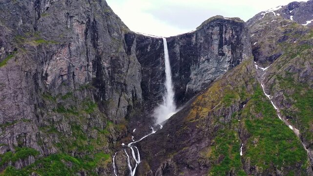 Aerial view of Mardalsfossen waterfall cascading down a steep rock face with green vegetation clinging to the rugged terrain, Eikesdal, More og Romsdal, Norway.