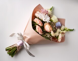 small bouquet of pastel flowers wrapped in paper and laid on white background