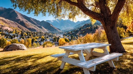 A picnic table beneath a tree overlooking a valley in autumn.