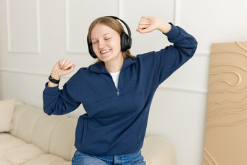 Woman with headphones at home on the couch. Listening to a podcast or live broadcast. Rest at home....