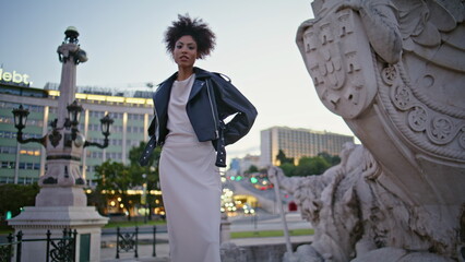 Tourist standing historic sight Lisbon Pombal square at evening. African woman 