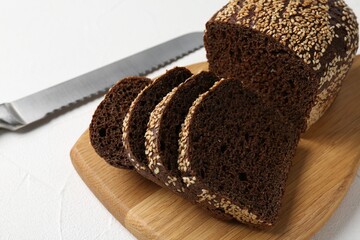 Pieces of fresh rye bread with seeds on white table, closeup