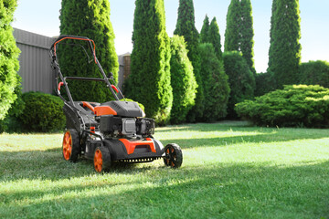 One lawn mower on green grass in garden, space for text