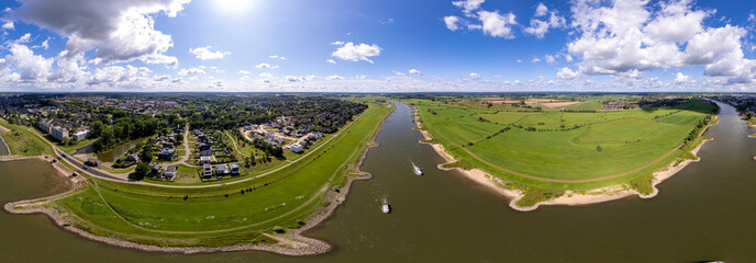 Wide aerial 360 panorama Dutch landscape with river IJssel passing by tower town Zutphen showing...
