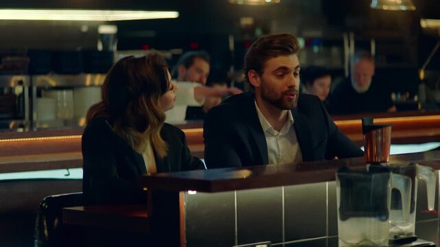 Beautiful Caucasian couple having a date in a stylish restaurant, talking and laughing. Shot with 2x anamorphic lens