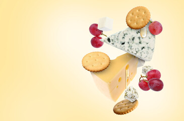 Cheese board products in air on beige gradient background. Different types of cheese, grapes, crackers and honey