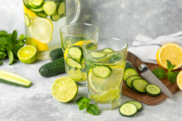 Cucumber water with lemon, lime and mint on a wooden table. Water infused with sliced...