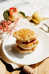 Homemade apple fritters stacked on plate, honey dripping, fresh apples in background, sunny countryside vibe.