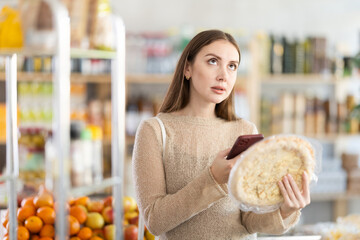 Before buying cheese pizza, girl scans barcode QR code on label of pizza package, follows link and...