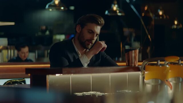 Beautiful Caucasian male sitting in a stylish restaurant, drinking cocktail. Shot with 2x anamorphic lens