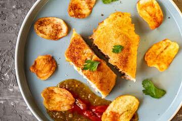 Chicken stuffed with bacon and cheese, fried in lision. A traditional French dish cordon bleu on a blue plate. Close-up