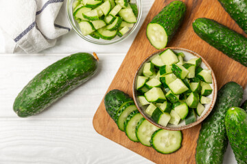 Cucumber on wooden background. Slice of cucumber on background. Fresh organic green cucumbers gherkin. Vegan. Salad ingredient. Farm vegetables. Cut vegetables with knife. Space for text. Copy space