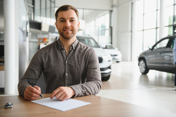 Customer signing contract for new car in dealership showroom